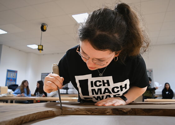 Mit vollem Fokus bei der Arbeit: Ashley Wedler (14) entfernt mit einem Stemmeisen überstehende Leimreste vom Olivenholz. Foto: Patrick Heckler